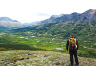 Fireweed geologist standing on a ridge overlooking Macmillan Pass.