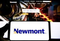 A smartphone displays Newmont’s logo in front of mining company’s webpage.