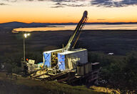 A western Alaska sunset colors the horizon behind a drill at Graphite Creek.