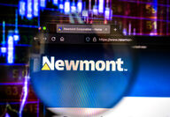 Newmont webpage in front of digital stock chart representing increased value.