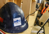 A blue hardhat with the BMC Minerals logo sits on shelf at the ABM Mine camp.