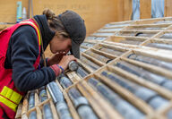 Snowline geologist examining drill core closely using a loupe.