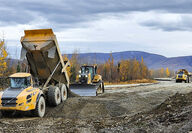 Truck dumps gravel to be leveled and compacted for the Manh Choh road.