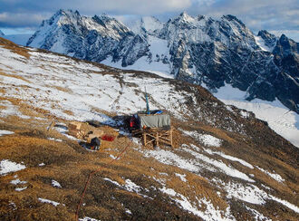 drill test for copper and gold and a partially snow-covered mountain slope.