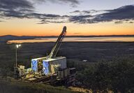 A colorful sunset paints the horizon orange at the Graphite Creek project in AK.