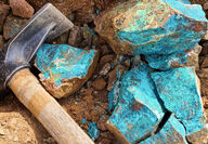 Hammer placed beside highly copper mineralized rock samples.