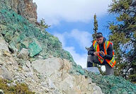 Gladiator geologist inspecting highly mineralized surface copper.