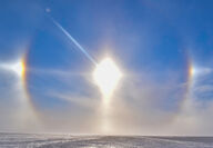 A colorful sundog encircles the sun over a frozen plain in Canada’s North.