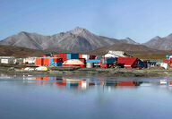 The buildings housing the mill and other Red Dog facilities reflect off a pond.