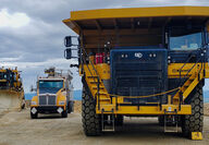 A large Cat mine truck, water truck, and dozer at the Manh Choh gold mine.