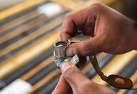 Geologist holds a loupe over a sample from the Turnagain nickel-cobalt deposit.