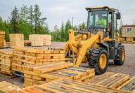 Front loader organizing pallets full of drill core.