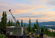 A drill tests for copper on the side of a forested hill in southwest Yukon.