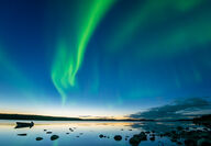 Bright green aurora seen over a shore in Nunavut, Canada.