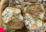 Two softball-sized rock samples with quartz and copper-gold mineralization.