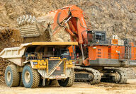 A Komatsu excavator loads ore into a Cat haul truck at the Fort Knox gold mine.