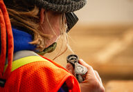 A geologist uses a loupe to take a closer look at drill core.