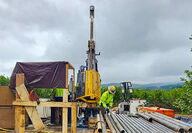 A worker readies a pipe segment at drill rig testing for nickel in Alaska.