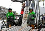 Drillers in grease-covered raingear give a thumbs up at the Arctic Mine project.